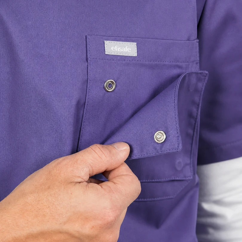 Close-up of a purple work shirt pocket being closed with a snap button; a small white 'efisafe' tag is visible above the pocket.