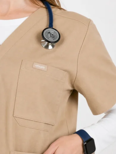 Beige medical scrubs with a front pocket, a stethoscope draped over the shoulder, and a blue smartwatch on the wrist.