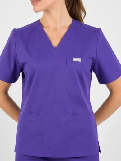 Purple medical scrubs top on a model with a V-neck, short sleeves, chest pocket with logo, and two lower front pockets.