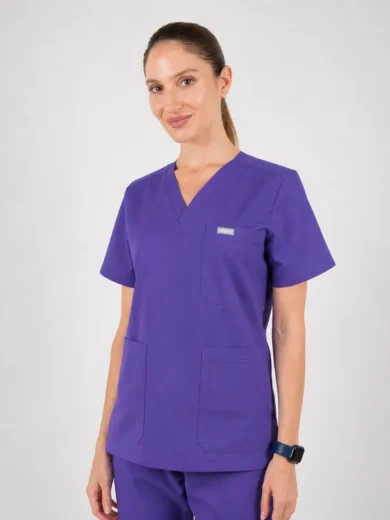 Woman in purple medical scrubs with V-neck and short sleeves, standing against a neutral backdrop.