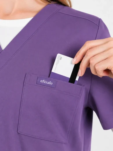 Purple scrub top with front pocket and label; hand places a card into the pocket.
