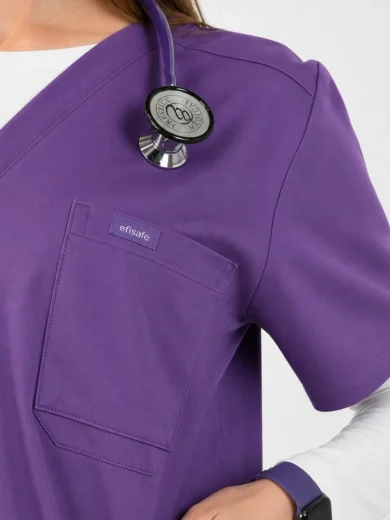 Purple medical scrub top with front pocket and stethoscope resting on shoulder; brand tag 'efisafe' visible on pocket.