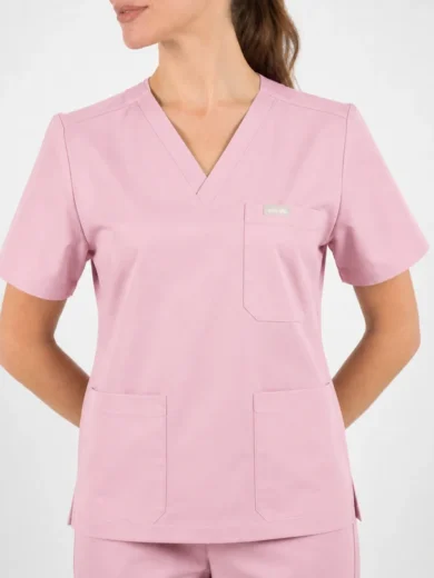 Pink medical scrubs top with V-neck, short sleeves, and chest pocket with small label; two lower front pockets visible.