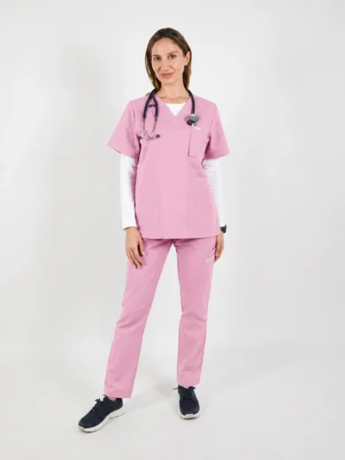 Nurse in pink scrubs with stethoscope around her neck, standing against a light background.