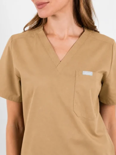 Beige scrub top with a V-neck and left chest pocket on a model.