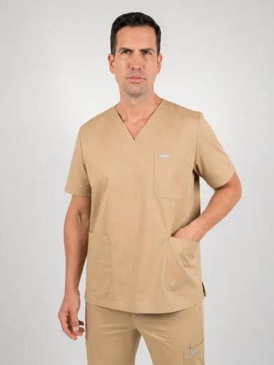 Man wearing tan medical scrubs with V-neck top and pockets, standing against a light gray background.