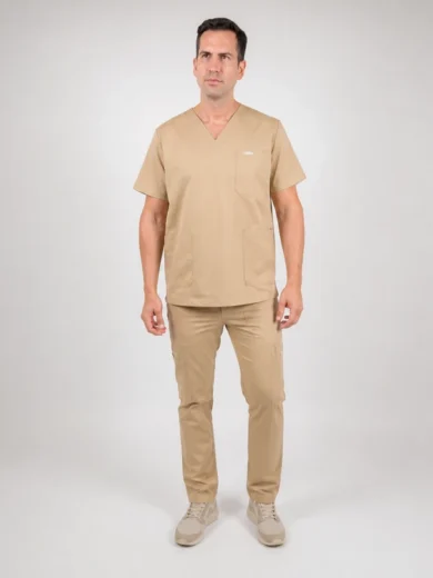 Man wearing beige medical scrubs (top and pants) standing against a neutral background, hands relaxed at sides.
