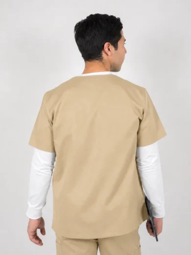 Man wearing beige medical scrubs seen from the back, holding a clipboard in his right hand, white long-sleeve undershirt visible under the top.