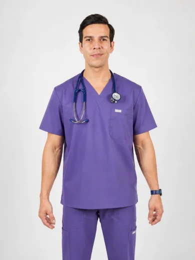 Male healthcare professional wearing purple scrubs with a stethoscope around his neck, standing against a neutral background, facing the camera.