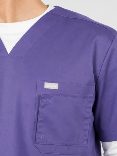 Close-up of a purple scrub top with a chest pocket and white undershirt.