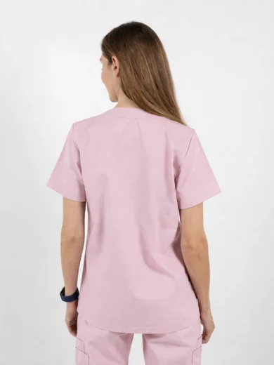 Back view of a person wearing light pink scrubs, short-sleeve top and matching pants, standing against a white background, showing the uniform from behind.