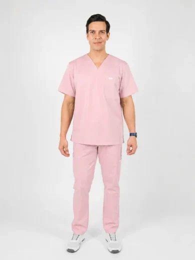 Adult male model in light pink medical scrubs standing against a white backdrop, hands at sides.