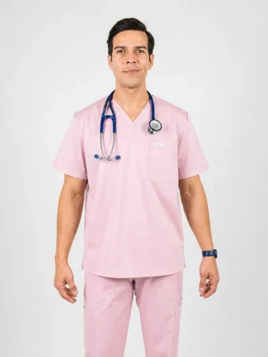 Male healthcare worker in pink scrubs with a stethoscope around the neck, standing against a light background.
