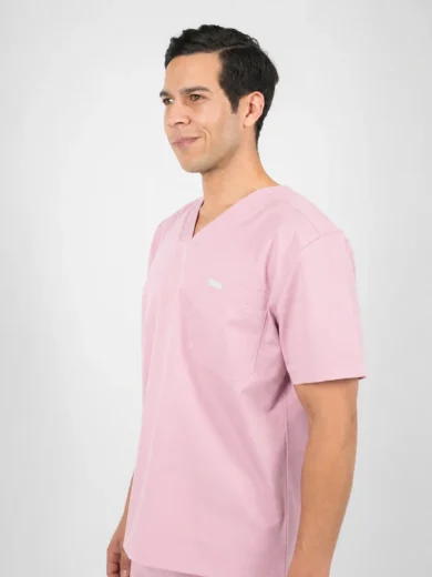 Man in pink medical scrubs standing in profile against a light gray background.