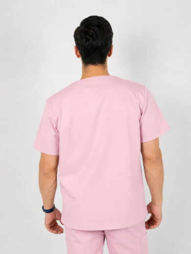 Back view of a person wearing light pink scrubs, short-sleeve top and pants, standing against a neutral background.