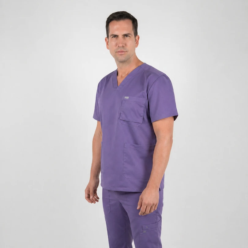 Man modeling purple medical scrubs with V-neck top and multiple pockets, standing against a light gray background, facing slightly to the left.