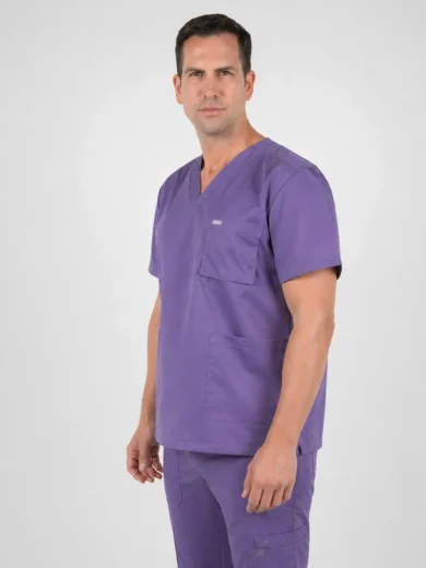 Male model wearing purple medical scrubs (V-neck top with chest pocket and matching pants) against a light gray background.