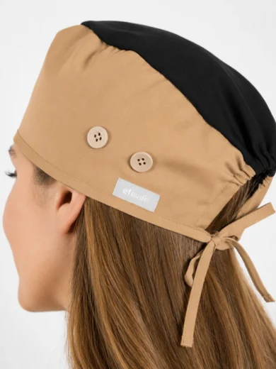 Beige and black surgical cap viewed from the side, with two beige buttons and a tied back strap on a person’s hairline headband area but not showing face clearly due to angle, label reads efisafe on the side.