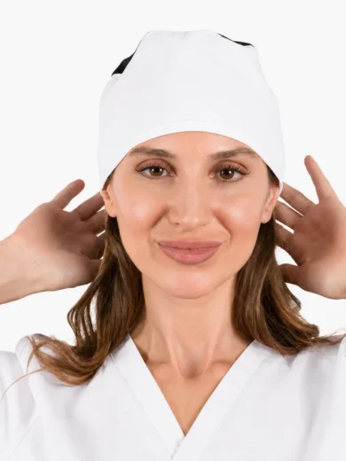 Female healthcare worker wearing a white surgical cap and scrubs, facing the camera with hands near her ears.