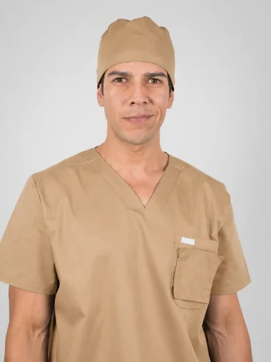 Front-facing man in tan medical scrubs and cap, against a light gray background.