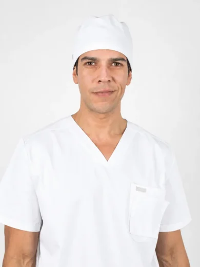 Male healthcare professional wearing white scrubs and a surgical cap, facing the camera with a neutral expression.