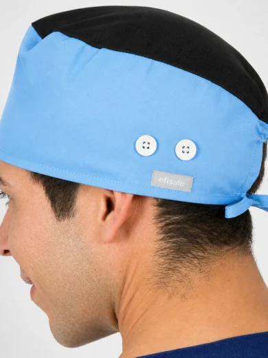 Side profile of a man wearing a blue surgical cap with a black top, two white buttons, and a back tie (Efisafe).