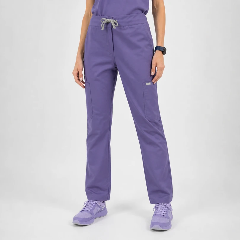 Person wearing lavender scrub pants with a drawstring waist and cargo pockets, paired with lavender sneakers.