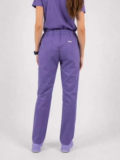 Back view of a person wearing matching purple scrubs: a short-sleeve top and elastic-waist pants with back pockets and a small logo near the right back pocket, jogger-style legs, paired with purple shoes.
