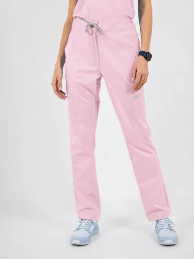 Full-length view of light pink scrub pants with a gray drawstring and front pockets, worn with light blue sneakers and a dark wristwatch.