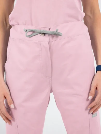 Light pink jogger pants with a grey drawstring tied at the waist, shown on a person from the waist down.