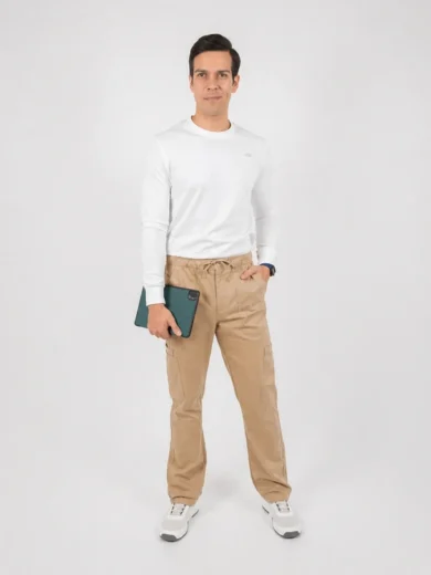 Man posing in a white long-sleeve shirt, beige cargo pants, and white sneakers, holding a teal tablet in his left hand.