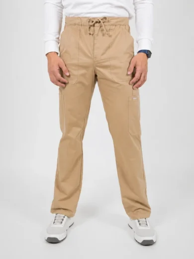 Man wearing tan cargo pants with a drawstring waist, white long-sleeve shirt, and white sneakers, standing against a neutral backdrop.