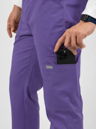 Person in purple scrubs slides a smartphone into the front pocket on the right leg/side pocket.