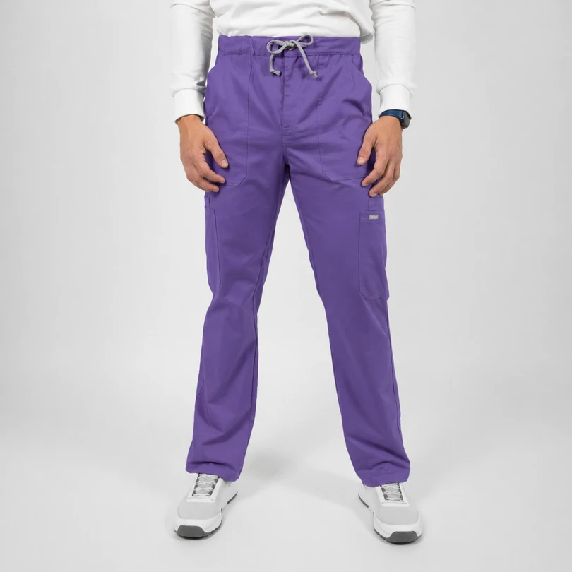 Man wearing purple cargo pants with a drawstring waist, front pockets, and white sneakers on a plain backdrop.